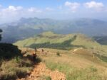 Parent and child trekking through lush green hills and coffee plantations in Coorg